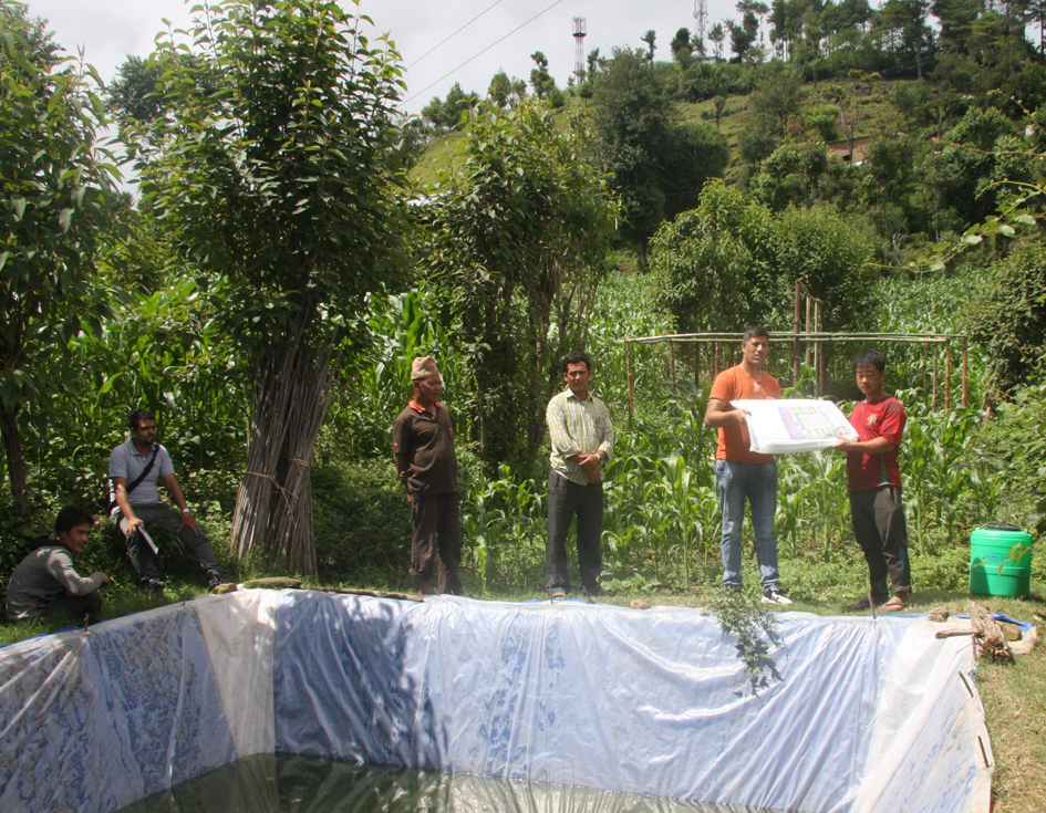 Pax Earth Member Kapi Deuja distributing a drip irrigation kit and a Silpaulin sheet to a farmer in Kot Timal village.